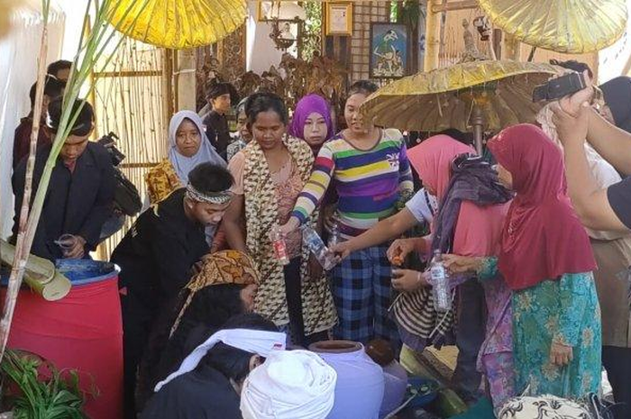 Warga berebut air hasil pencucian benda pusaka yayasan Al-Awaliyah Padepokan Nur Sedjati, Kamis (7/11/2019)