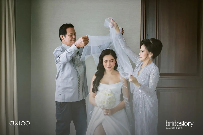 Dalam foto lainnya, Hardi Iskandar terlihat membantu Jedar mengenakan veil sebelum memasuki tempat acara pernikahan. 