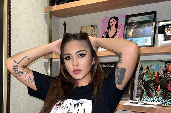 Foto tato putri Nurul Arifin menjadi sorotan. Punggungnya digambari tato sebuah kepala setan dengan lidah api menyala.