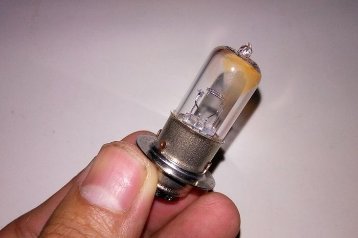 Ilustrasi jangan sembarangan memegang bohlam lampu halogen motor.