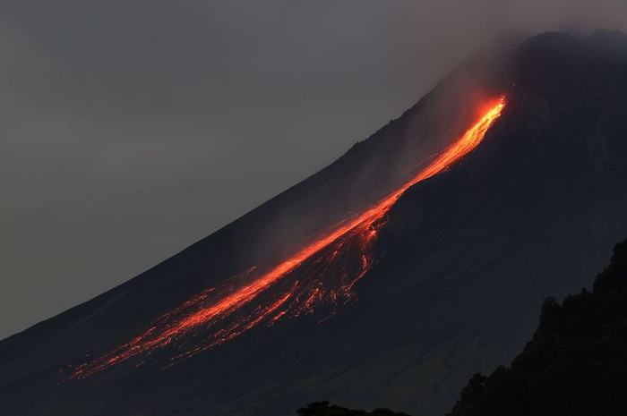 Gunung Merapi mengeluarkan guguran lava pijar terlihat dari Dusun Turgo, Desa Purwobinangun, Kabupaten Sleman, Kamis (23/12/2021).