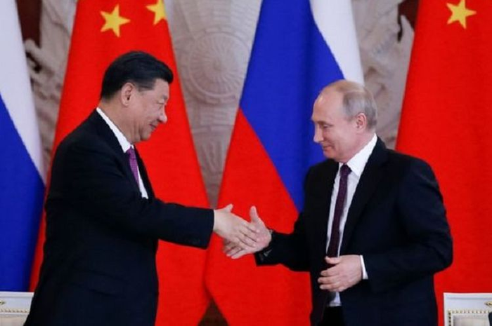Presiden China Xi Jinping ketika berjabat tangan dengan Presiden Rusia Vladimir Putin.