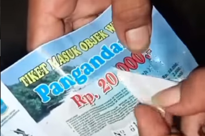 Seorang pengunjung Pantai Pangandaran membongkar tiket yang harganya mahal.