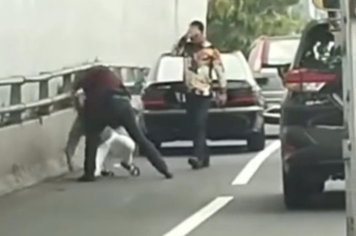 Netizen dibuat heboh gegara foto aksi pemukulan yang dilakukan pengemudi mobil plat pejabat RFH di tol. Polisi ungkap faktanya.