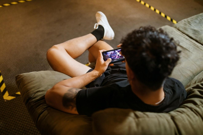 Ilustrasi bermain game online di smartphone.