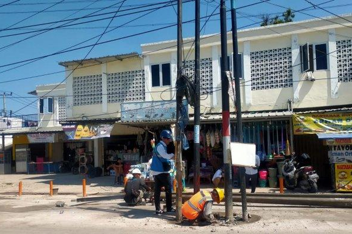 Pemotor heran ada tiang listrik di tengah jalan raya di Cikarang, Kabupaten Bekasi, Jawa Barat.