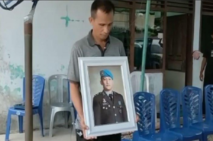 Foto Samuel Hutabarat membawa foto Brigadir J. 