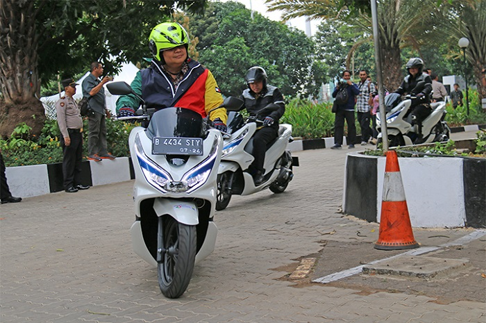 Menko Perekonomian Airlangga Hartanto mengendarai motor listrik Honda PCX Electric.