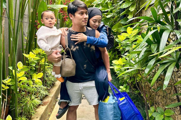 Rizky Billar gendong sosok anak dan istri, Lesti Kejora sambil tenteng tiga tas.