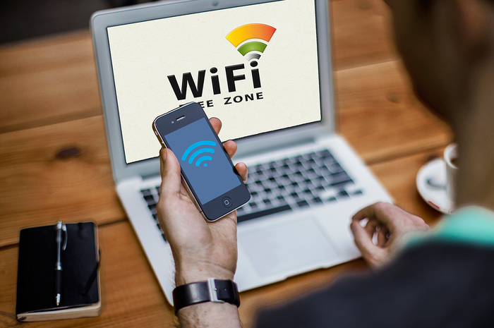 Ilustrasi mahasiswa sedang menggunakan apalikasi pencari WiFi umum untuk mengakses internet. 
