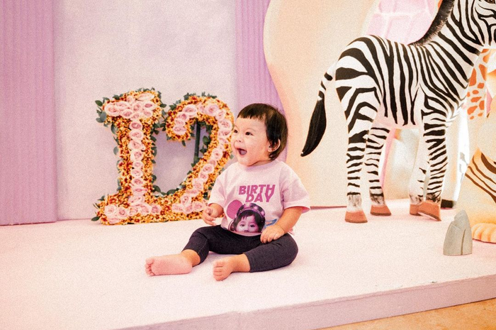 Ameena berfoto di dekat hiasan zebra