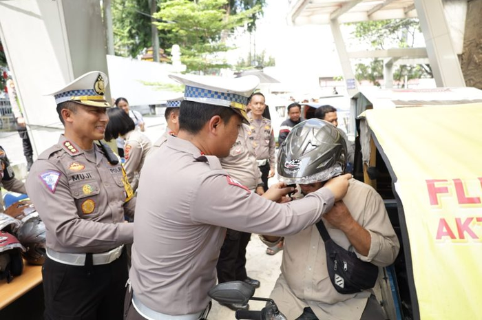Polda Sumut membagikan 200 helm kepada tukang bentor atau beca bermotor yang jarang pakai helm. 