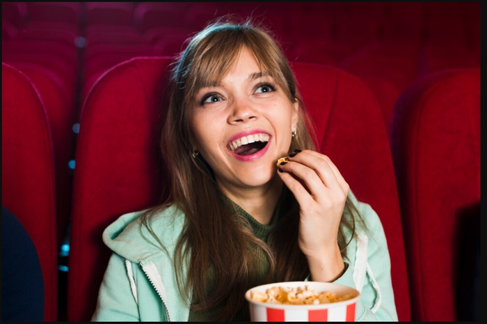 Ilustrasi makan popcorn saat nonton di bioskop