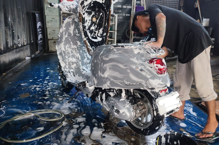 Ilustrasi. Cuci motor Vespa matic demi hindari muncul panu di body!