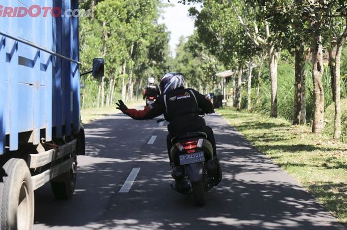 Ilustrasi motor mendahului truk. 