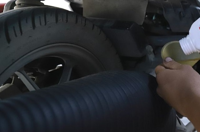 Foto ilustrasi penuangan pelumas mesin. Perhatikan ciri-ciri oli palsu dan bahaya untuk motor.
