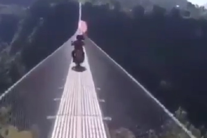 Dua pengendara motor melintasi jembatan yang bikin jantung copot.