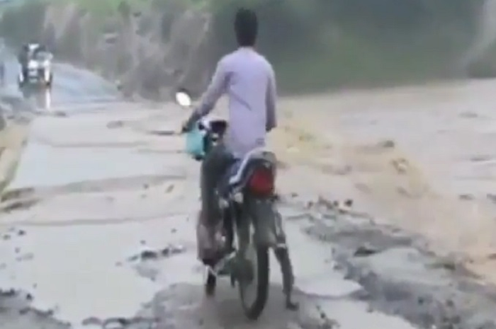 Seorang pengendara motor nekat melibas banjir.