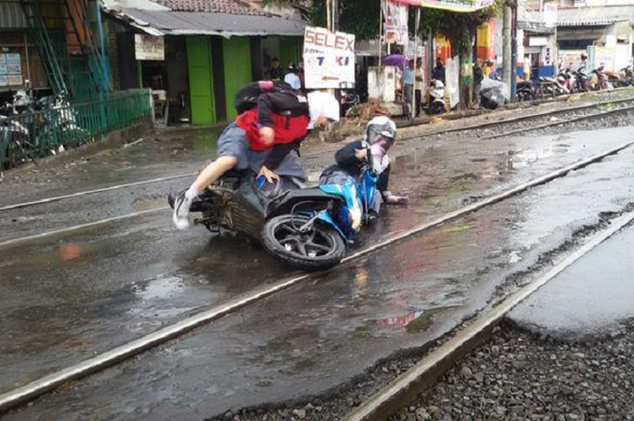 Pengendara motor terjatuh saat melintasi rel kereta api.