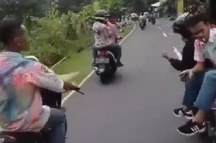 Siswa terjengkang di aspal saat merayakan kelulusan sekolah.