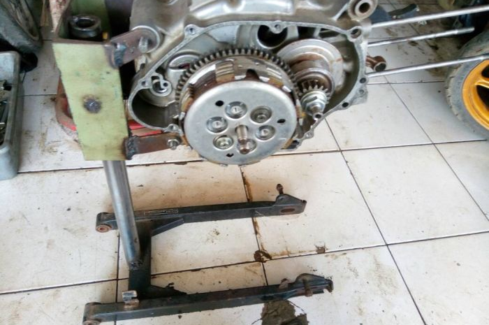 Pegangan mesin saat bongkar butuh yang kokoh. Dulu pakai boks kerat botol. Ini cara lain dengan memanfaatkan swing arm bekas. 