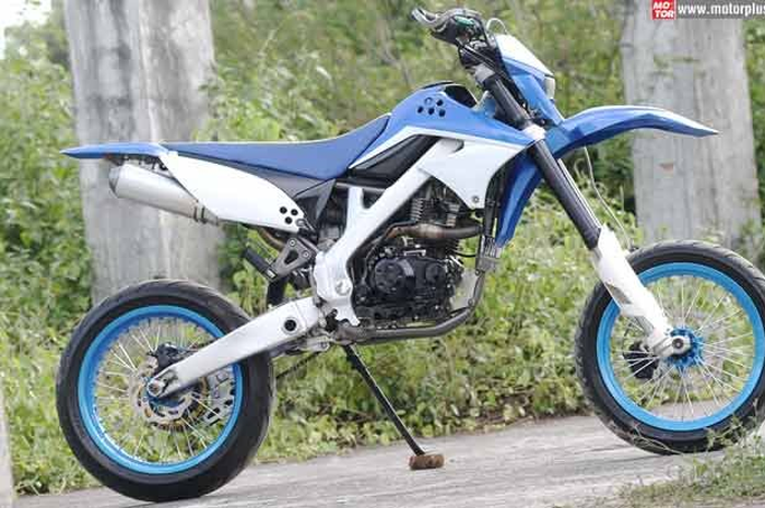 Bentuk supermoto yang gagah dengan postur tinggi, menjadi idaman Ade Nugroho. Dengan modal kuda besi milik sendiri, lajang yang berprofesi sebagai pengatur muatan kargo kapal laut di Pelabuhan Semarang ini coba kustom tampilan D-Tracker yang posturny