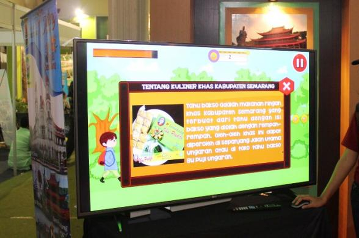 Lidya sang pembuat permainan sedang memeragakan simulasi aplikasi permainan tersebut.