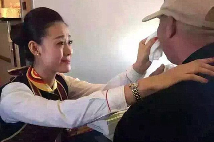 Pramugari ini Membuat Semua Penumpang Tersentuh saat Berlutut demi Menyuapi Penumpang Tua yang Difabel