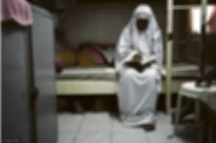 Seorang wanita yang tengah berdoa 