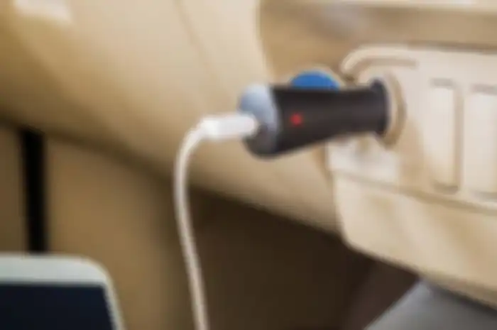 Ilustrasi mengecharge HP di mobil