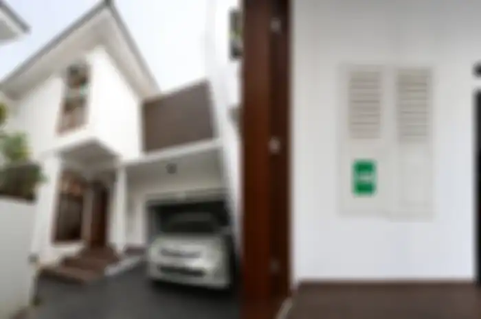 Fasad dengan desain modern dan permainan garis dan kotak. Jendela bekas jadi tempat nomor rumah.