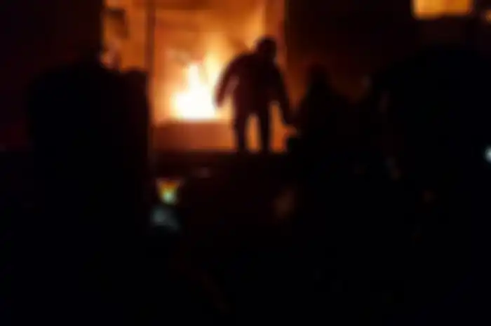 Tim pemadam kebakaran sedang menjinakkan api yang membakar gedung.