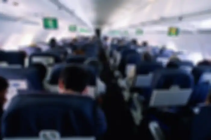 Passengers sitting in commercial airliner, rear view