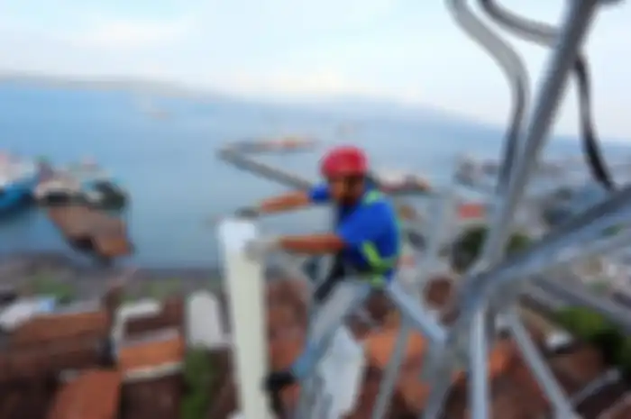 Teknisi XL Axiata melakukan pemeliharaan perangkat BTS di atas tower yang berlokasi di sekitar lokasi penyeberangan feri Pelabuhan Ketapang Banyuwangi, Kamis (14/3/2019)