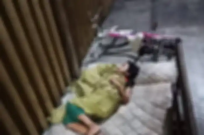 Seorang bocah tidur sendirian di depan ruko