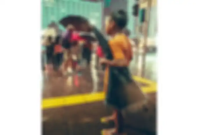 Foto seorang anak yang tengah mencari uang dengan menjadi ojek payung di Jakarta. 