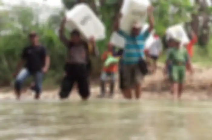 Para petugas menyeberangi sungai Beng saat mendistribusikan kotak suara berisi surat suara Pemilu 2019 untuk TPS 10 di Dusun Nampu Desa Klitih Kecamatan Plandaan Kabupaten Jombang, Selasa (16/4/2019). 