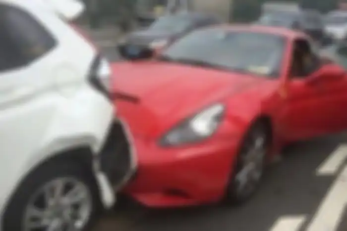 Mobil Ferari merah menabrak mobil Honda di depannya.
