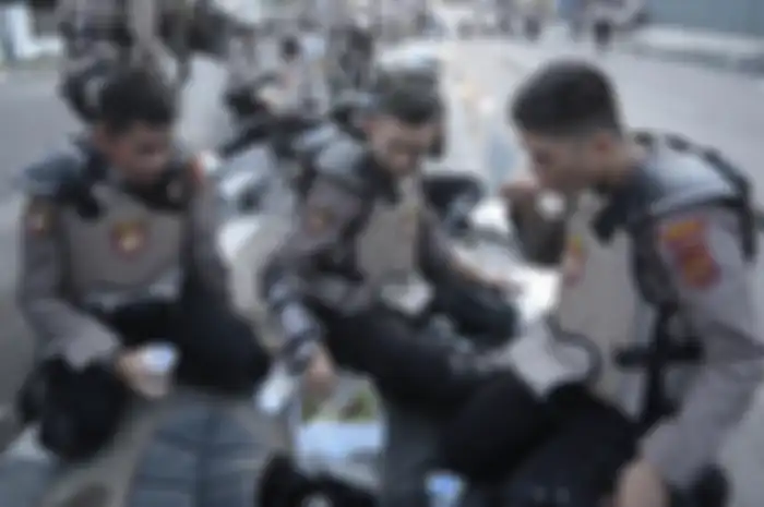 Personel Kepolisian berbuka puasa di tengah mengamankan jalannya aksi unjuk rasa 22 Mei di Jalan Brigjen Katamso, Slipi, Jakarta, Rabu (22/5/2019).