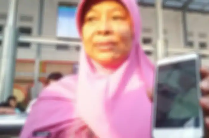 Yuli (58) memperlihatkan fotonya bersama Presiden RI Joko Widodo saat keduanya berswafoto di Stasiun Pasar Senen, Jakarta Pusat, Jumat (31/5/2019). 