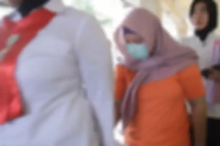 Pembunuh ayah kandung, Hilda Nurafriani alias Ani (30), digiring dua Polwan Polres Kota Mataram. (Foto: Kompas.com/Fitri Rachmawati)