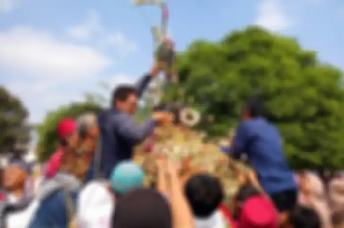 Warga masyarakat saat berebut gunungan yang terbuat dari hasil bumi di Masjid Gedhe.