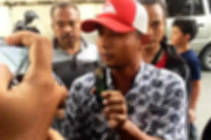 Sofyan menunjukkan foto anak dan istrinya yang tewas dalam kebakaran pabrik macis di Langkat.(Handout)