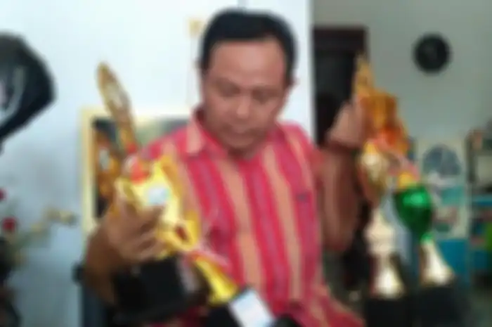 Ayah Y, Sugeng Witoto (50) saat memperlihatkan piala yang didapatkan oleh anaknya, Rabu (26/06/2019).