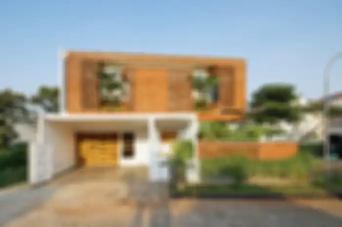 Tampak depan rumah dengan fasad yang didominasi material bata merah.