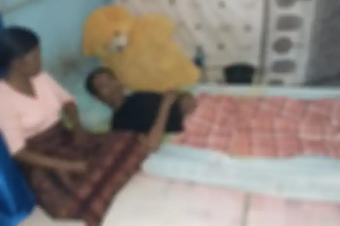 Ambrosius Roliyanto (34) saat terbaring di kamarnya ditemani sang isteri Barbara Adinda (32), di Kelurahan Wailiti, Kelurahan Alok Barat, Kabupaten Sikka, Flores, NTT, Jumat (12/7/2019).  