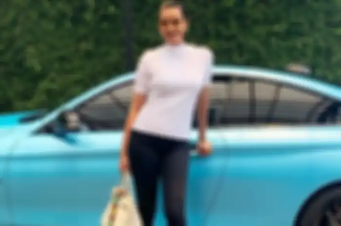 Kimmy Jayanti berpose di depan BMW kesayangannya.