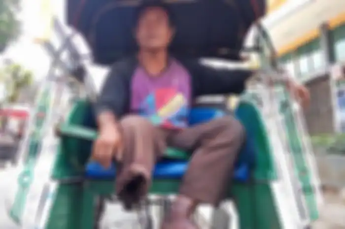 Wawan Setiawan saat berada di dalam becak menunggu penumpang di seberang Taman Budaya Yogyakarta (TBY)
