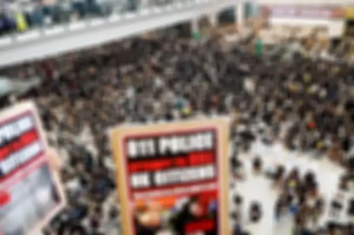 Massa pengunjuk rasa memadati aula kedatangan di Bandara Internasional Hong Kong, Senin (12/8/2019). Pengunjuk rasa yang mencapai lebih dari 5.000 orang memaksa dihentikannya operasional bandara.