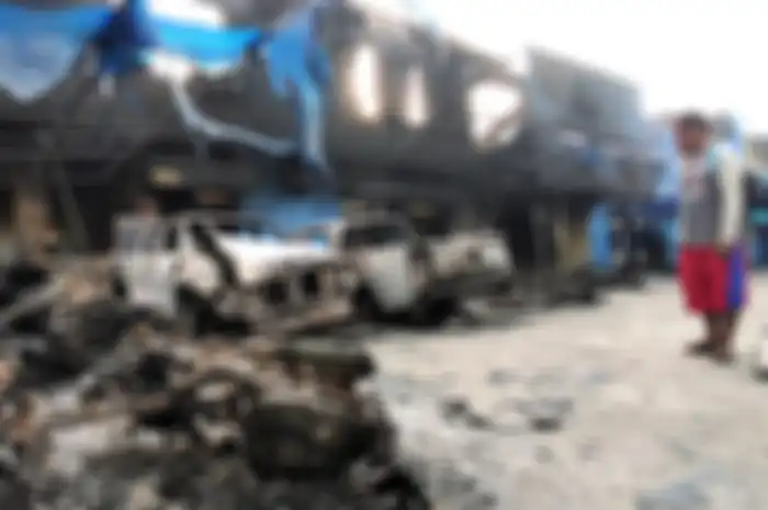 Seorang warga mengamati Kantor Bea Cukai Papua serta sejumlah mobil yang terbakar saat berlangsungnya aksi unjuk rasa di Jayapura, Papua, Jumat (30/8/2019). Sejumlah bangunan dan kendaraan terbakar saat aksi pada (29/8/2019). Sejumlah bangunan dan kendaraan terbakar saat aksi unjuk rasa yang berakhi